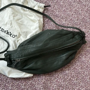 Marimekko ”Karla”. - Tidig modell av Marimekkomönstrens Karla i mörkgrönt. Slitet välanvänt skick.