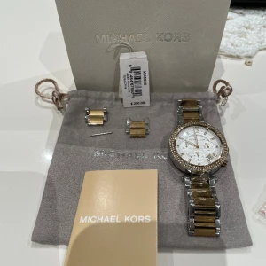 MICHAEL KORS KLOCKA GULD MK5626 - MICHAEL KORS KLOCKA. Ägt klockan i 3 år och köptes i USA, butik Macys. Felfri Förrutom ett par repor på armbandet, inga sprickor eller liknande och finns förlängningsbara delar. Kommer med box, påse. Köptes för 250$. Pläterad i Guld, grund silver.