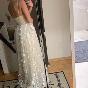 Balklänning  - Säljer min balklänning som tyvärr inte kom till användning i färgen champagne med vita blommor i tyll. Storlek 34 Nypris 2500kr  🌸🌸🌸