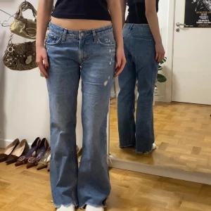 Blå lågmidjade jeans med slitningar - Blåa 90’s flare jeans från H&M. Står strl 40 på lappen men skulle säga att de är mer som en 36/38. Midjemått 39 cm, ytterbenslängd 102 cm och innerbenslängd 80 cm. Använda några fåtal gånger bara.🖤