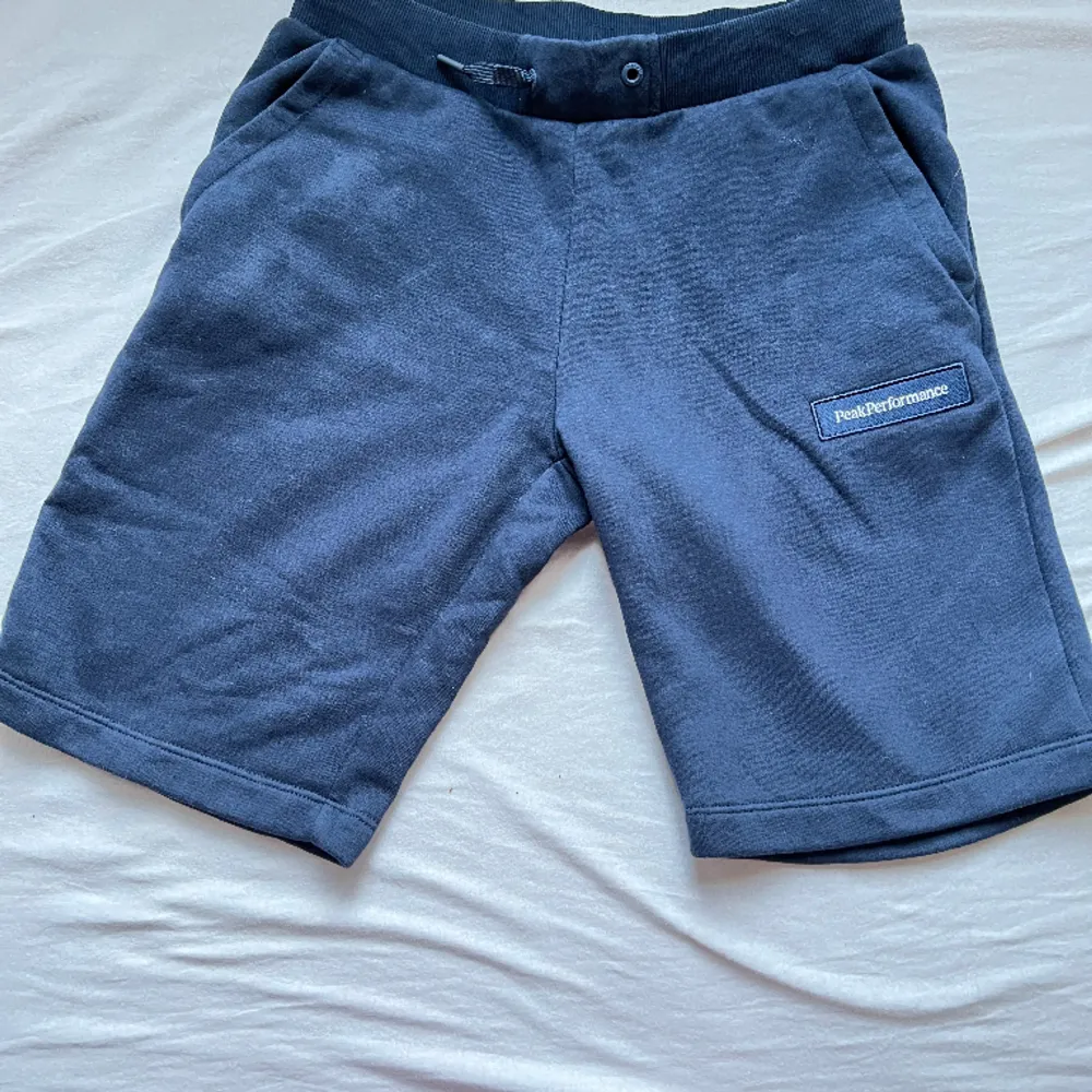 Ett par mörk blåa Peakperformance shorts.. Shorts.