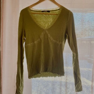 Grön gullig långärmad topp med spets från Bik Bok - Den tröja är perfekt till vardags, älskar att den har en dekorativ spets söm runt halsen🥰. 