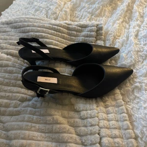Klackar  - Svarta spetsiga klackar från Nelly, köpte till nyår men va snöstorm kunde ej använda. (Inga defekter aldrig använda). Justerbara i hälen, klackhöjd 6 cm. Ord pris 499