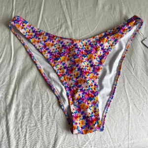 Helt ny bikiniunderdel! - Helt ny, aldrig använda bikiniunderdel från Bright Swimwear i modell Capri, färg night floral. Nypris på hemsidan är 30 dollar vilket motsvarar ca 315kr. Den är i storlek M. Gå gärna in på hemsidan och se när en modell har på sig den!