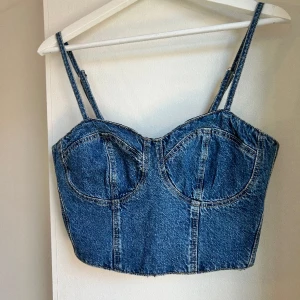 Crop bustier denim - Crop bustier i denim från Nakd   Polyester 75, bomull 25%   Skick: inget att anmärka pga helt oanvänd med lappen kvar!