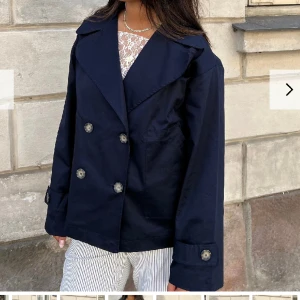 Trenchcoat  - Säljer denna marinblå trenchcoat från design by si. I bra skick och bara använd ett fåtal gånger. inte min bild💞