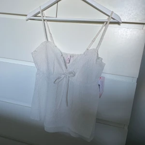 Topp - Supersöt topp från Nelly i storlek XS, helt oanvänd med lappen kvar 🫶🏻 den är krämvit/beige, svårt att få till helt på bild🌸