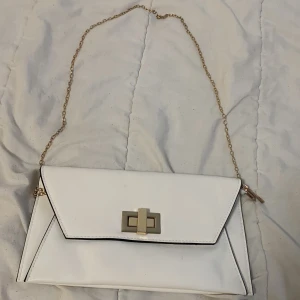 Axelremsväsk  - En vit festlig Axelremsväsk med guld detaljer och knappt använt. 💗