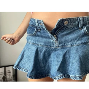 jeans kjol med volang - Säljer min URSNYGGA jeans kjol från bershka. den är helt oanvänd dock har jag tagit bort lapparna.. råkade beställa i en förliten storlek! men kan lova att den är oanvänd utan defekter.