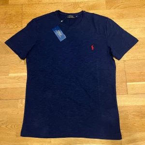 Ralph Lauren T-shirt - Snygg Ralph Lauren t-shirt i storlek M. Tröjan är aldrig använd och är i perfekt skick. Lappen är även kvar. Perfekt till sommaren!