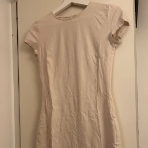Beige kort klänning  - Beige kort klänning från Nelly i storlek S. 