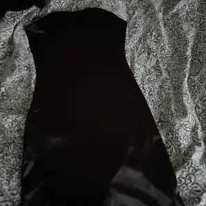 En svart medel lång tajt satin klänning ifrån Hm ej använd! 🤍