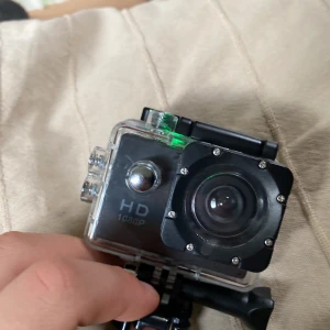 Gopro SJ4000 Sports camera - I princip nytt skick, filmar och tar bilder i 1080p HD. Kan ta bilder och spela in ljud. Ganska liten kamera och läns. Vattentätt Go PRO skydd.Minneskortet följer inte med då jag behöver det men om man erbjuder 200+ kan det följa med.