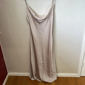 Festklänning - Festklänning som är nyskick, fler bilder skickas vid önskemål, färgen är rosa guld 