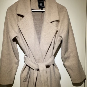 Lång beige kappa - Beige kappa från Marc Lauge. Änvänd ett fåtal gånger så den är i superfint skick. Storlek s/36. Säljer denna för 350 då jag köpte den för 1250kr och den är 1år gammal.Vid eventuella frågor skriv till mig i chatten💕kan diskutera priset vid snabbt köp.