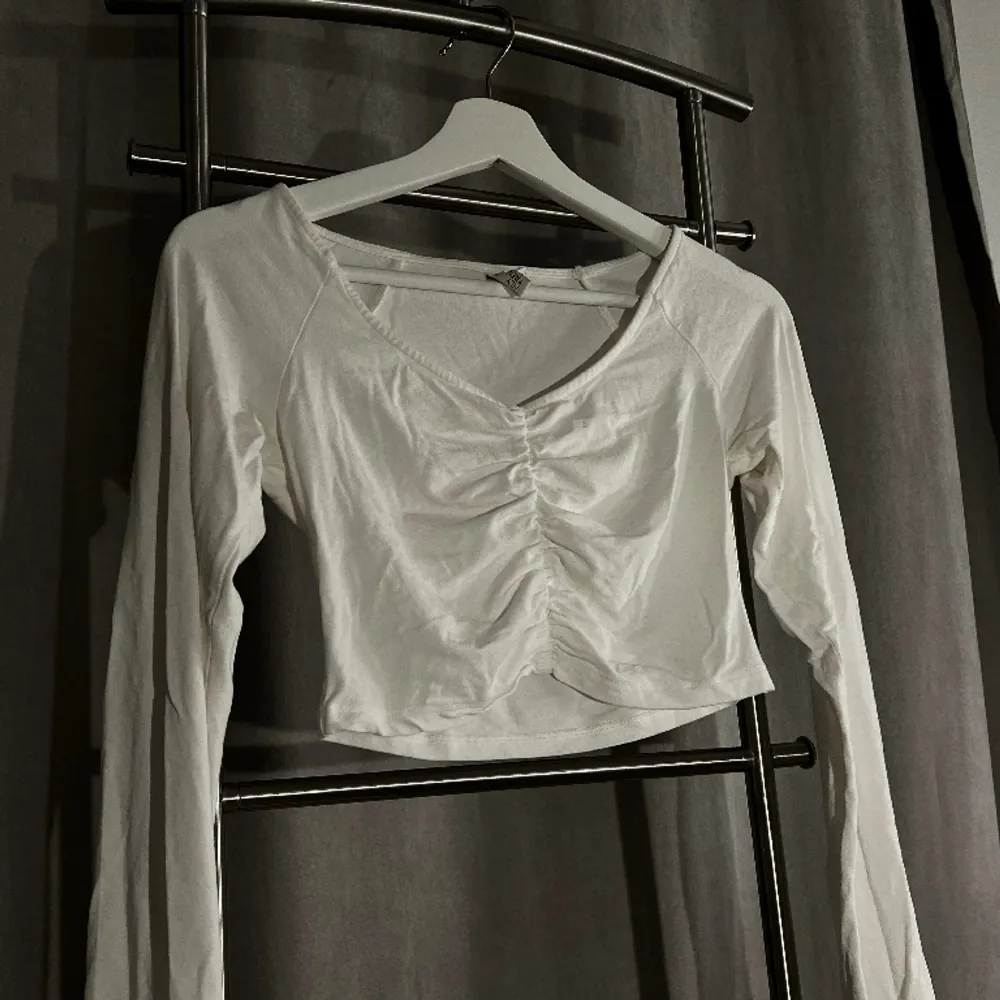 En vit långarmad croppad vit tröja från Nelly i storlek S. Tunn men inte genomskinlig.. Tröjor & Koftor.