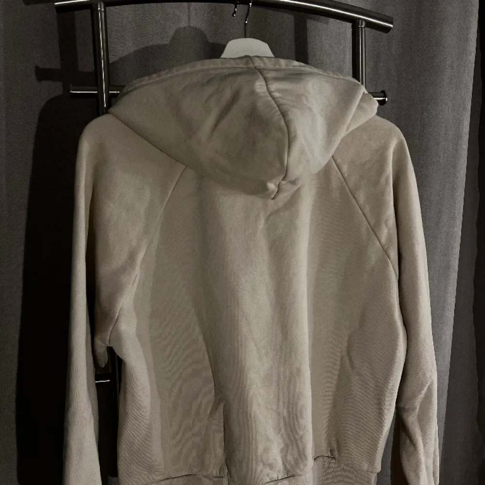 En ljusbeige hoodie från Gina Tricot med blå tryck (text ) på bröstkorgen. Storlek S passar även XS. . Hoodies.
