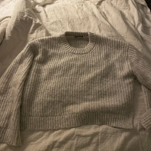 Gina tricot Stickad kofta - Ljusgrå tjockt stickad kofta med slits i ärmarna och på sidorna, mycket bra skick och använd få gånger