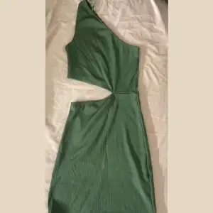 Säljer denna fina one shoulder ribbade gröna klänningen med en öppning på högra sidan. Storlek xs. Från pull and bear använd 1 gång. 