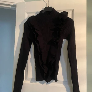 Snygg halvpolo  - Helt oanvänd tröja med volang och halvpolo. Tajt passform men stretchig. 