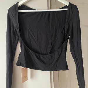 Tröja - Trendiga tröjan med öppen rygg i storlek M, aldrig använd prislapp kvar. Hör av dig vid intresse😊