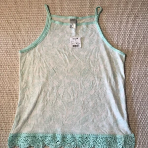 Vit ljusblått linne med detaljer  - Ett fint linne som är helt oanvänd. Prislappen är kvar. Bra skick 💗Girls 7-16