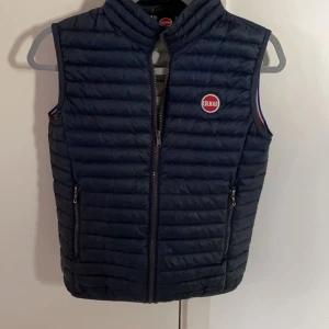 Colmar väst - Väldigt fin och stilren väst och perfekt till våren!, säljes eftersom den börjar bli för liten. Skick 8/10 ett litet hål som syns på andra bilden. Nypris runt 2500