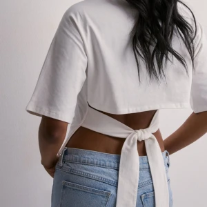 T-shirt med knytning/rosett - Jag säljer min vita tröja som man kan knyta vid ryggen, rosett eller det man föredrar. Den är i storlek S och har endast använts 1 gång. Nyskick!