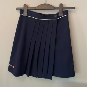 Tenniskjol  - En superfin marinblå tenniskjol från märket ellesse. Säljer då den blivit för liten. Nypris 320kr knappt använd.💗