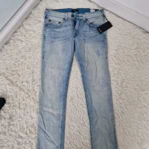 True religion jeans slim - Ett par sprillans nya ljusblåa True religion Jeans med balla slitningar.