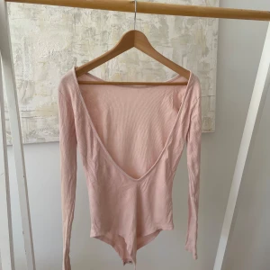 Body med djup urringning i rygg - Fin rosa top med djup urringning i ryggen. Storlek S/M.