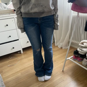 Lågmidjade bootcut jeans med hål - Köptes second hand. Lite för långa därför säljer jag . Aldrig använda. Mått ungefär 37 runt innerbens längd ungefär 80. INGE fler bilder ❤️
