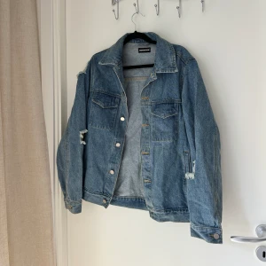 Jeansjacka  - Jeansjacka med slitningar i storlek 36. Mellanhårt material. Sparsamt använd. 