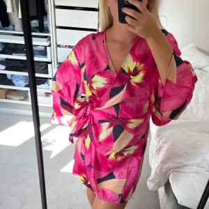 Söt klänning - Super fin klänning i magiskt mönster fårn HM. Går att knyta i midjan så kan variera lite i storlek. Rosa med lite gula blommor, helt oanvänd med prislapp kvar❤️