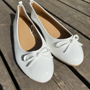 Ballerinaskor - Snygga vita ballerinaskor med prydnadsrosett i NY skick och storlek 40. Säljer dessa p.g.a fick fel storlek och kan inte returnera. 🩷