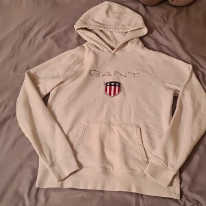 Hoodie (GANT) - Vit (GANT) hoodie. Passar på mig som har storleken XXS/XS💗 Finns att hämta i alsike/knivsta😊 Går också att posta om köparen betalar frakten💖