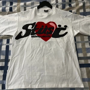 Stussy x CPFM Heart T-shirt - Säljer denna sprillans nya t shirt då jag ångrade mig efter jag hade köpt. Det är en fin Stussy t-shirt i collab med Cactus Plant Flea Market (CPFM). Den är i storlek Large men passar mig utmärkt som vanligtvis har M på kläder.  Kan fraktas🙃 