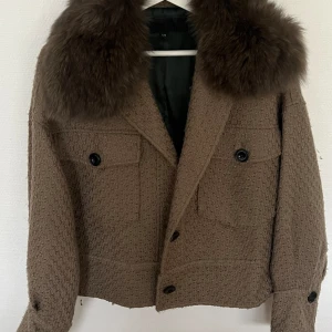 Meotine jacka - Säljer min meotine jacka. Den är kahki grön med mörkbrun päls. Jackan är i använt skick men det finns inga slitningar eller fläckar.