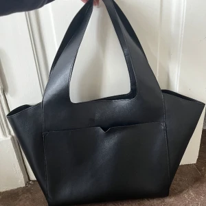 C.W. Väska - Svart stor toteväska från C.W. by Carin Wester. Använd fåtal gånger men lite knöglig här och där pga att den länge legat längst in i garderoben. Rymmer mycket.  Original pris 500kr Säljer pga att jag inte längre använder den. 