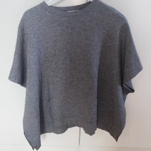 Grå Kort stickad tröja Zara  - Säljer min superfina korta stickade t-shirt från Zara då den inte kommer till användning längre. Perfekt skick och har inga defekter alls, tyget är superskönt och den sitter as snyggt på! Det är barnstorlekar men skulle säga att den passar XS-S ☺️