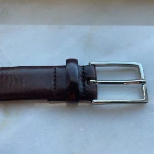 Saddler | Läder bälte  - Säljer ett Brunt Läder bälte från Saddler i mycket bra skick. Använt på två formella tillställningar. Slå en pling vid frågor och funderingar! :)