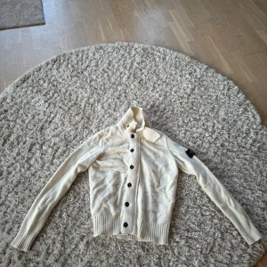 Stone island cardigan - En vit/krämvit cardigan från stone island. Skick 8/10. Säljer den då den är för liten för mig. Storlek S. Passar M med.