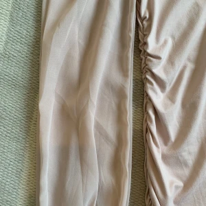 Ljusrosa klänning från Shein - En elegant ljusrosa klänning från Shein med långa ärmar och rynkade detaljer på sidorna. Klänningen har en fyrkantig halsringning och är tillverkad i ett mjukt och bekvämt material.