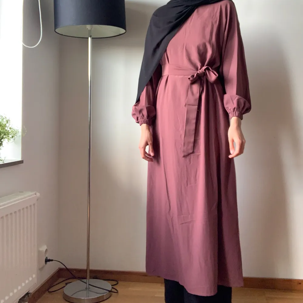Säljer abaya då jag är för lång för den. Nyttskick och kommer med matchande bälte. Fint ogenomskinligt material, har osynlig dragkedja i nacken och fickor! Behöver bara strykas. Längd är 133cm. Jag är ca 173cm lång för referens🩷Köpt för 500. Mekot.