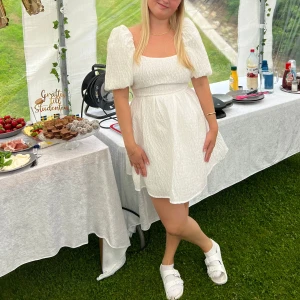 Vit sommar & studentklänning - Säljer min vita studentklänning från NA-KD i storlek 36, använd på studentdagen men är tvättad och är i nyskick då vi hade dräkter på flaket! Nypris 449kr