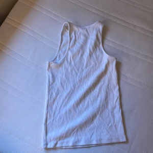 Vit linnetopp från H&M - En vit linnetopp från H&M i storlek S. Toppen är ärmlös och har en ribbad struktur.