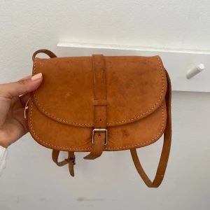 Liten brun väska  - Super gullig liten brun väska, perfekt för hösten. Säljer dåd en inte kommer till användning. Skriv för mått. Fått i present och osäker på märket 