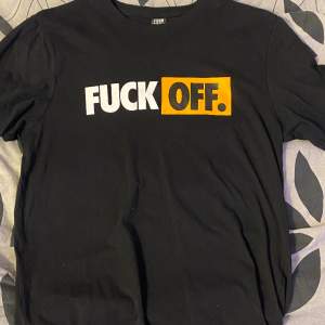 En svart tshirt med trycket ”fuck off”. Inte använd på något år och användts sällan