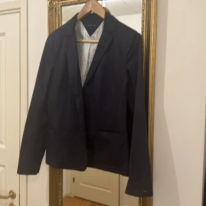 Mörkblå kavaj från Tommy Hilfiger - Fin kavaj till jeans , använt skick och utan knapp-därav priset! 
