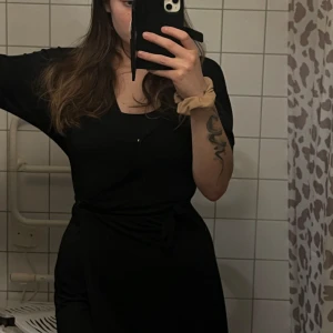 Svart Klänning  - Bra skick i storlek L. Har snören insydda på sidorna. Har även en knapp vid bysten, v-ringad men på bild har jag inte en passande topp under. 